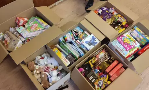 Zdjęcie kartonów zawierajacych, gry zabawki, książki i maskotki.